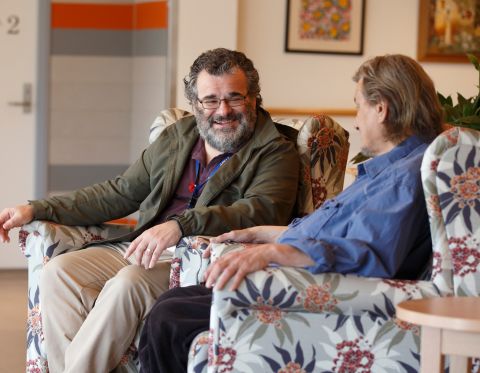 Two men sitting in armchairs and talking with each other